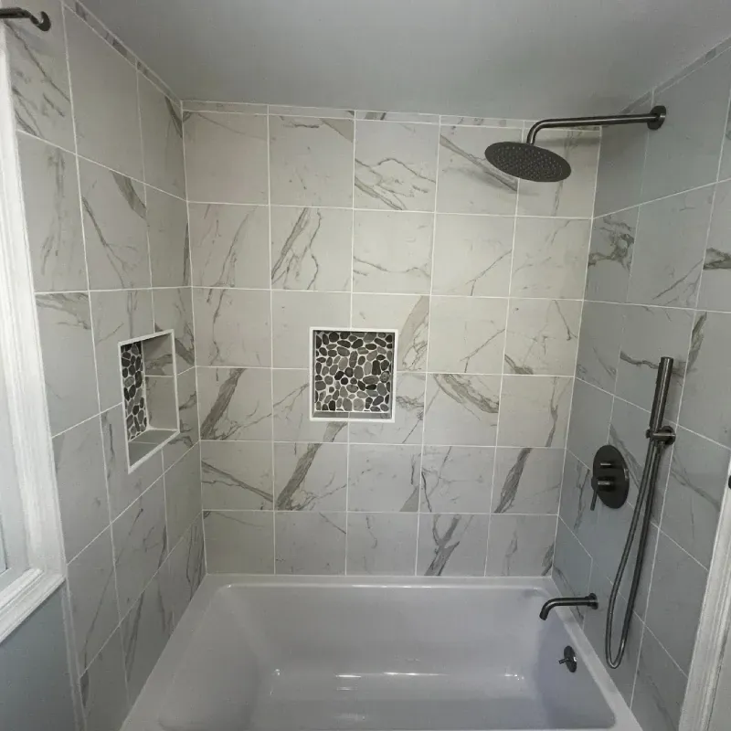 Marble-look tile tub surround with a tiled niche after bathroom tile installation
