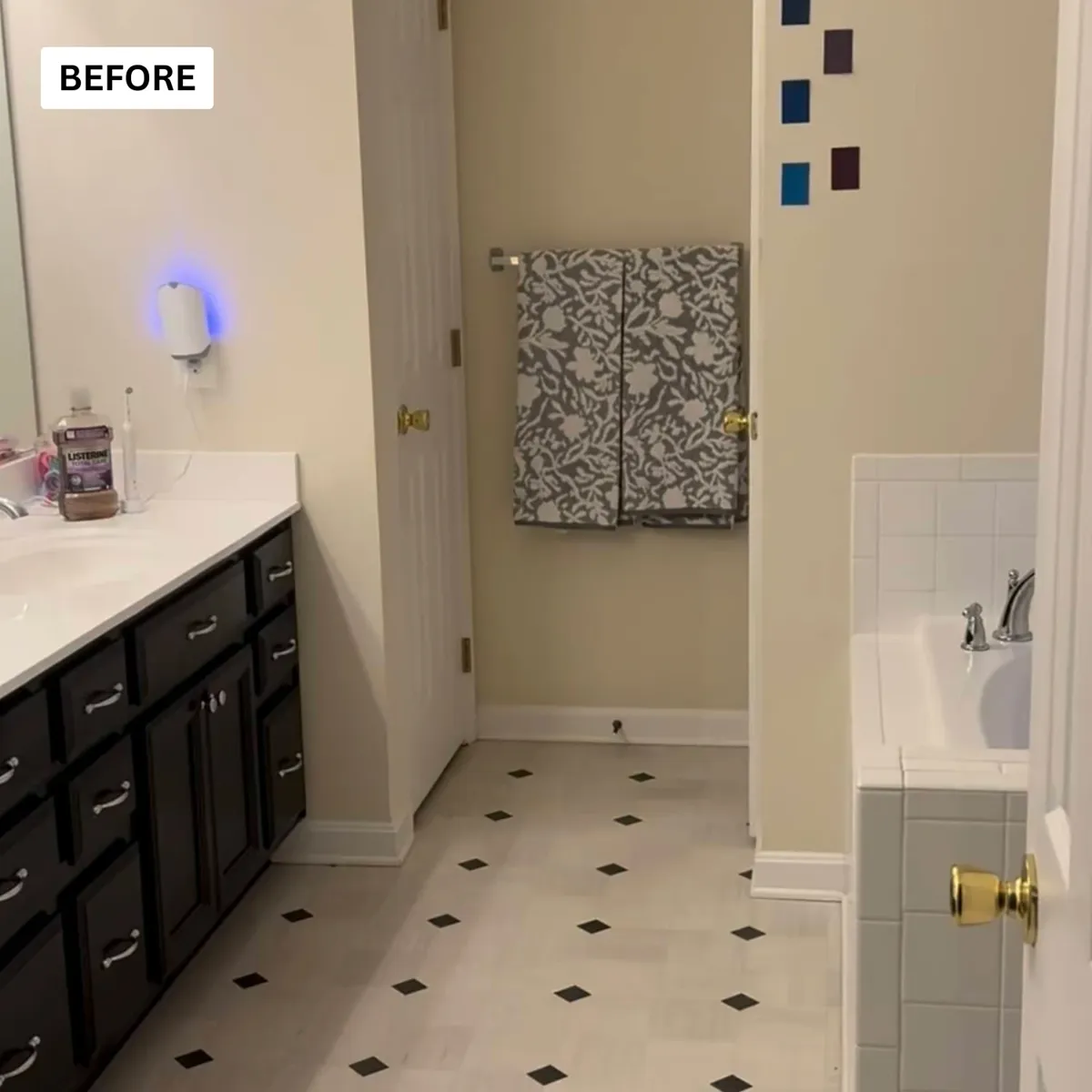 Long dark wood vanity with a white top in a bathroom before remodeling