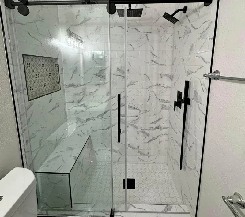 Frameless glass shower door over marble tile, Columbia MD