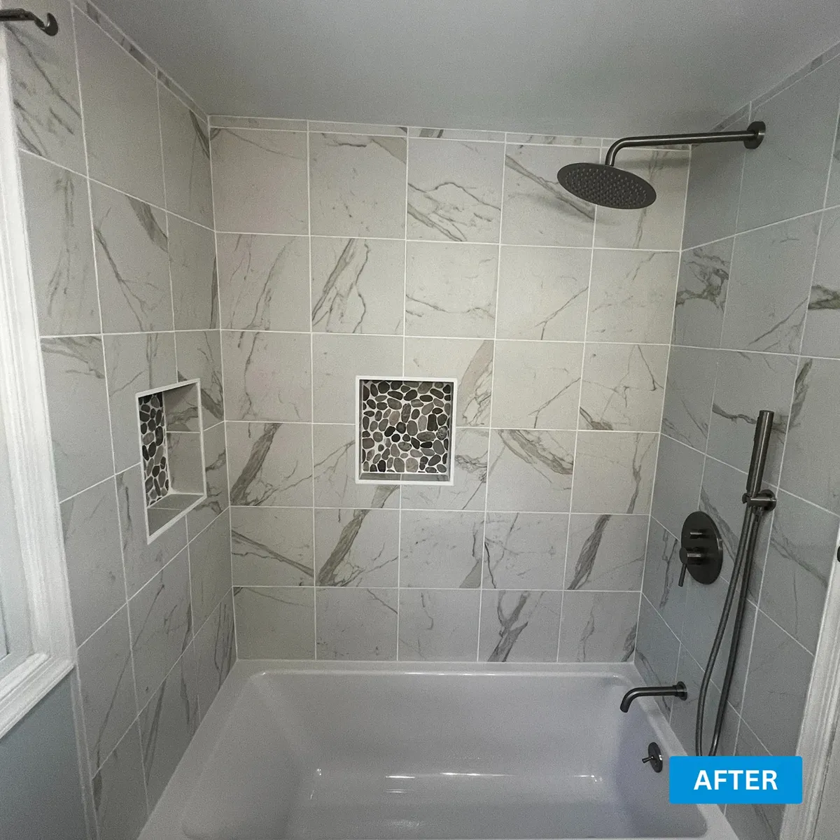 Marble look tile tub surround with a recessed niche and thin grout joints