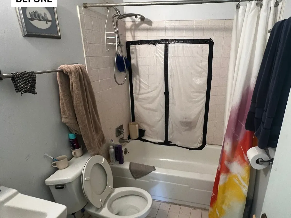 Old tub with a high wall and a shower curtain before an accessible bathroom remodel in Columbia MD
