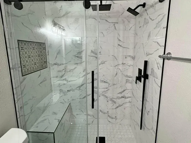 Tiled shower with a built in seat and a handheld sprayer after an accessible bathroom remodel in Columbia MD