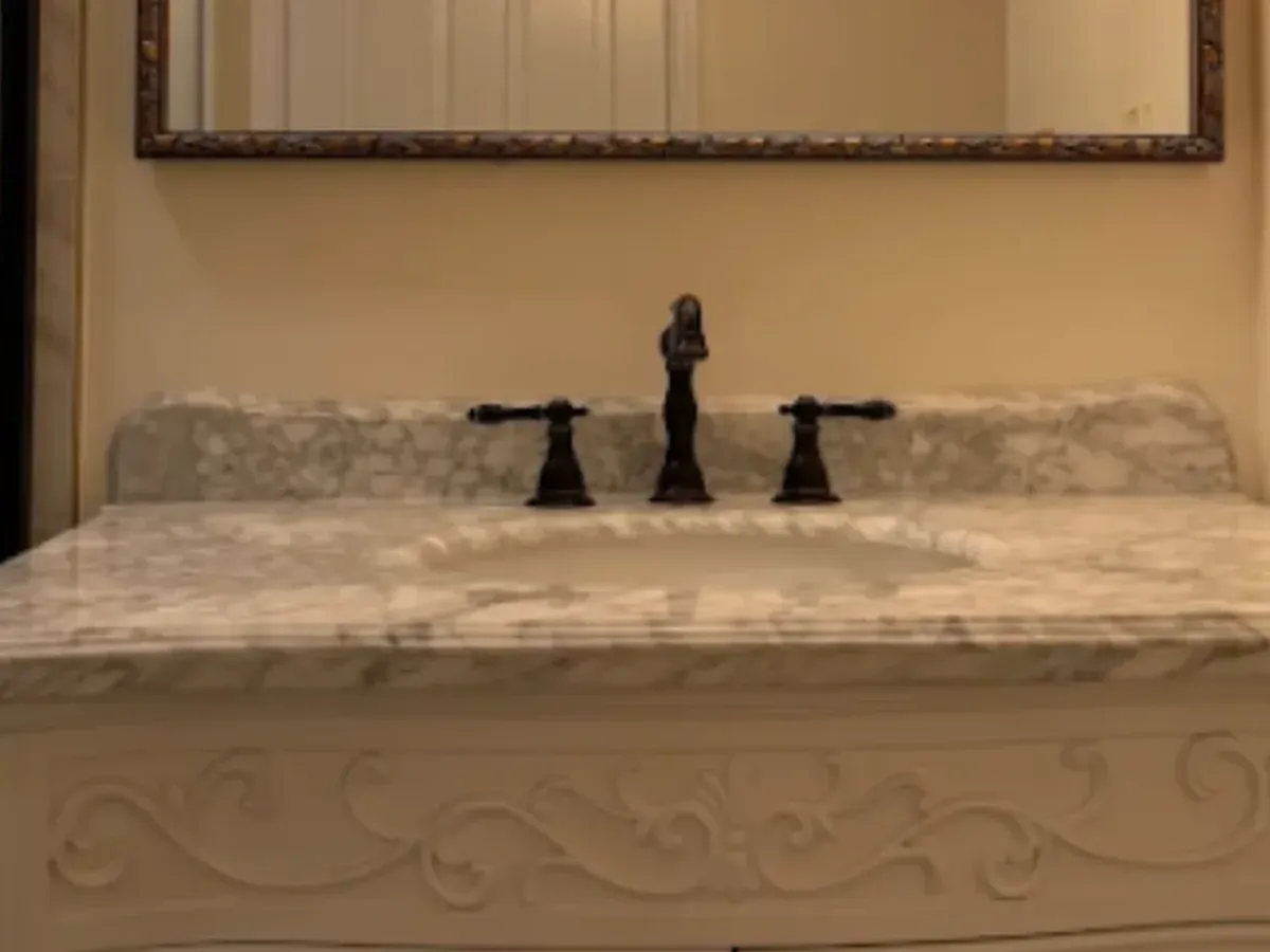 Marble vanity top with a widespread bronze faucet after bathroom countertop installation in Pasadena, MD