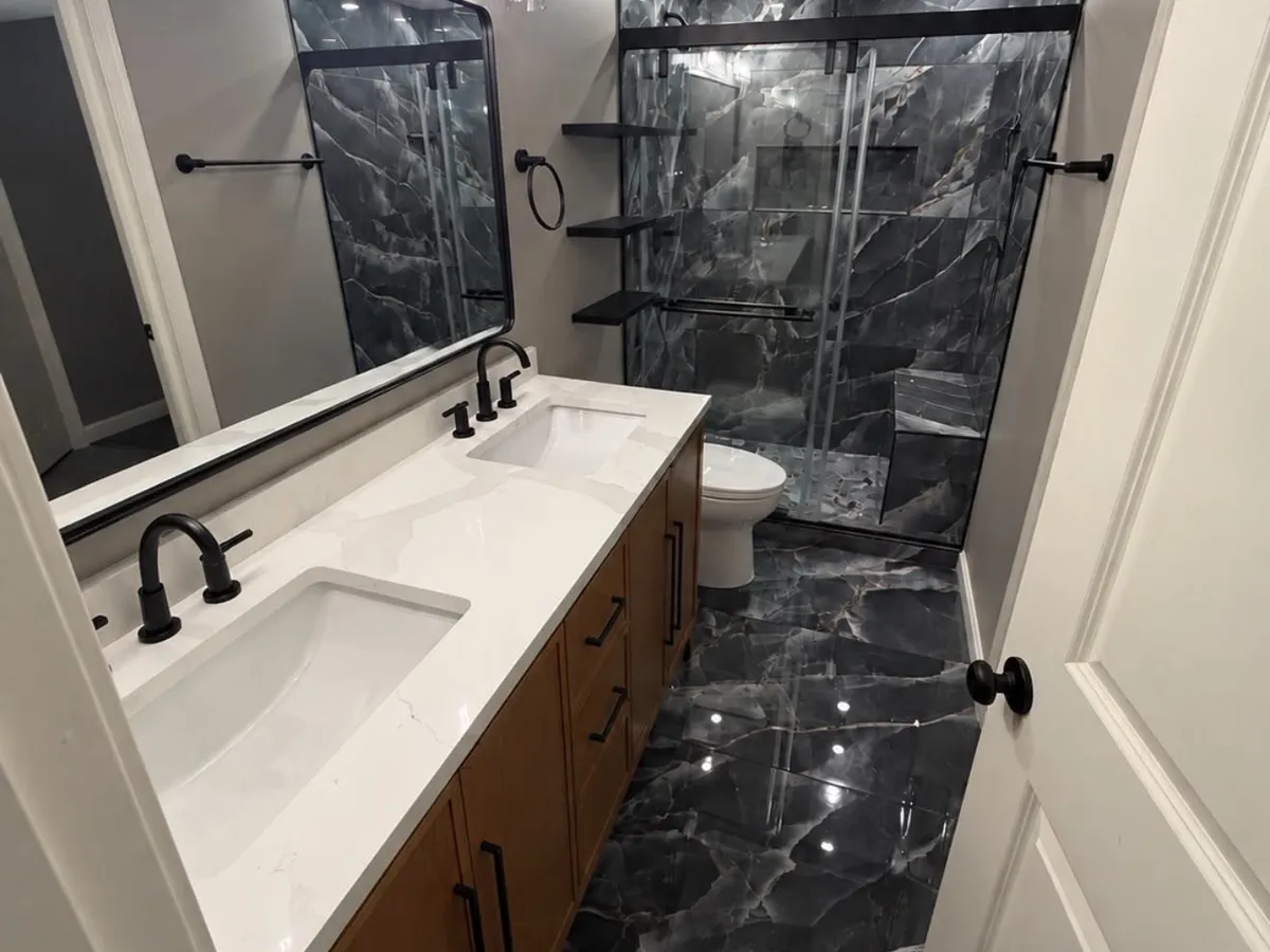 White quartz double vanity top above a black marble tile floor in a Pasadena, MD bathroom