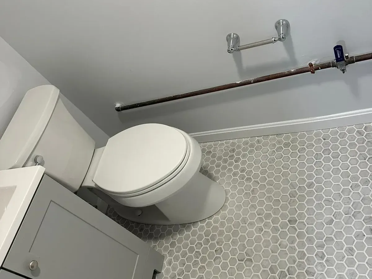 New toilet set on tile with its water supply line run on the wall during an Arnold MD bathroom remodel