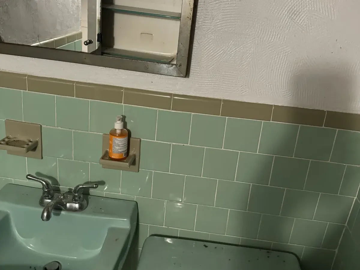 Old wall hung sink and toilet with dated supply lines before bathroom plumbing work in Arnold MD