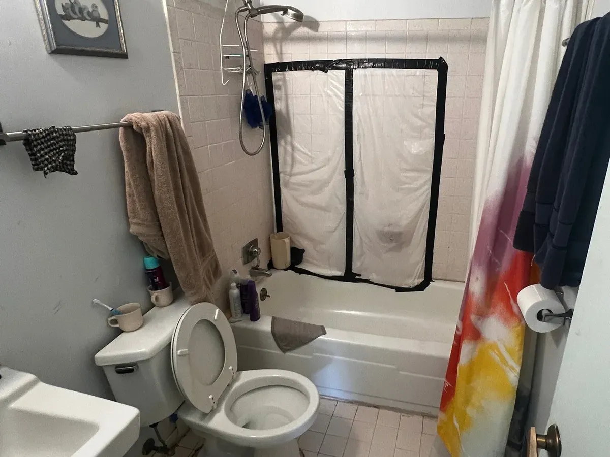 Dated tub, toilet and wall sink before bathroom plumbing work in a Columbia MD bathroom