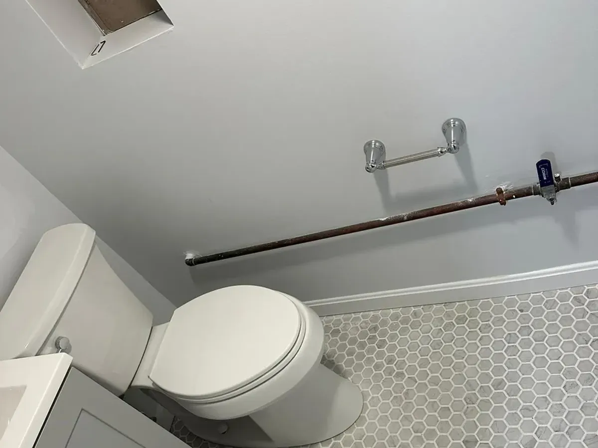 New tile floor fitted around a reset toilet after bathroom plumbing work in Columbia MD