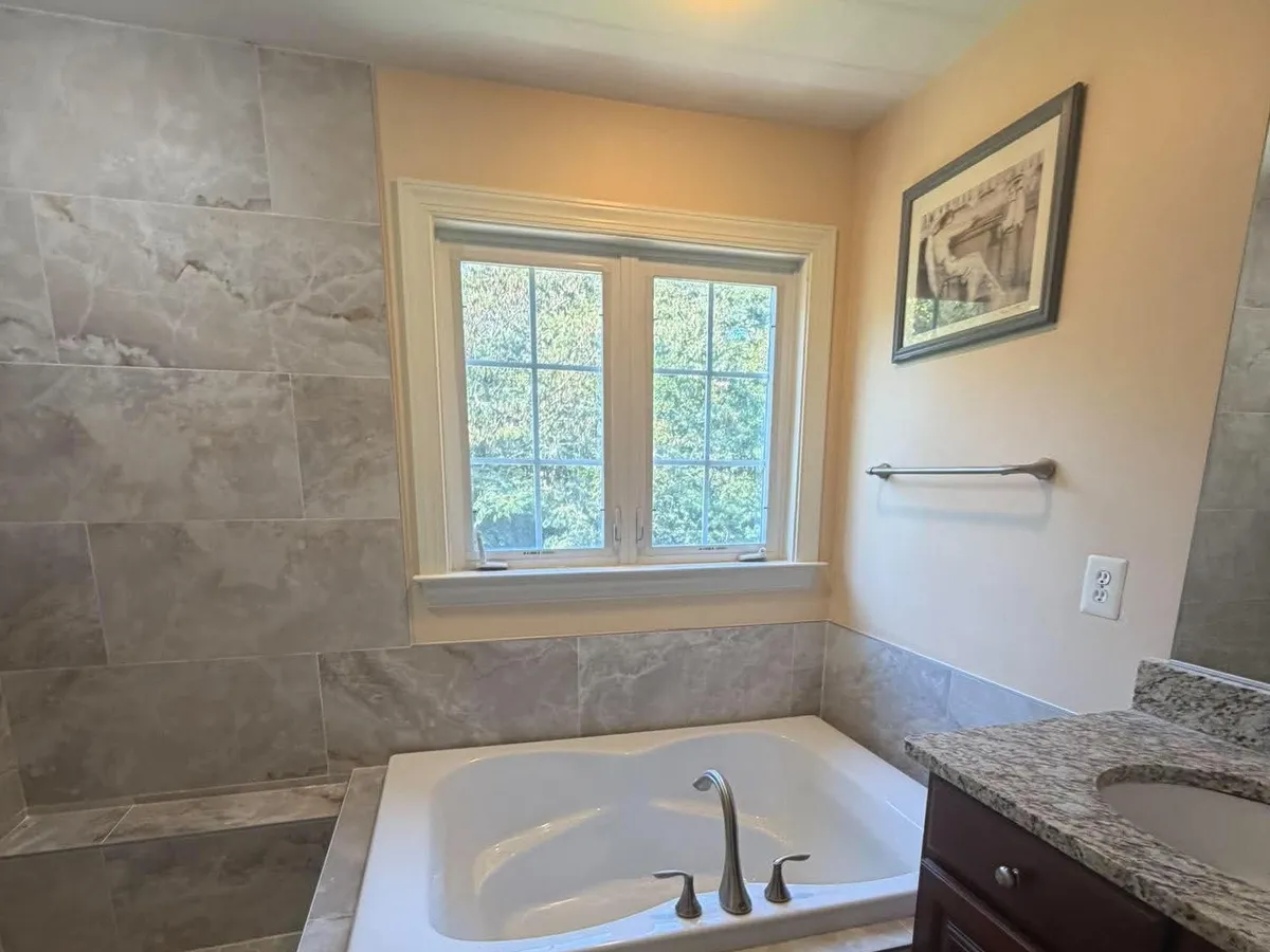Tile tub surround with a window above a soaking tub in a Pasadena MD bathroom
