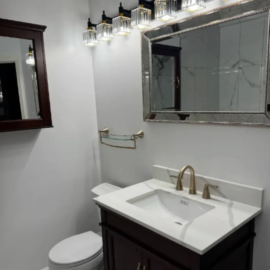 White quartz vanity top with an undermount sink and brass faucet in a Columbia MD bathroom